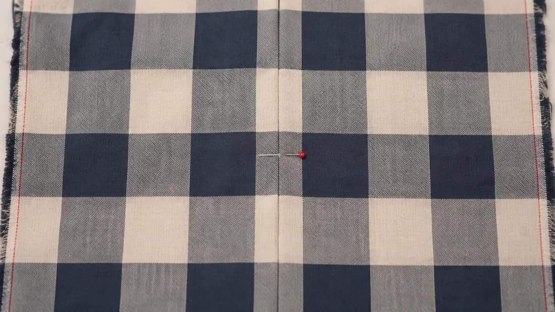 Two pieces of checked cloth held edge to edge with the check lines meeting exactly.