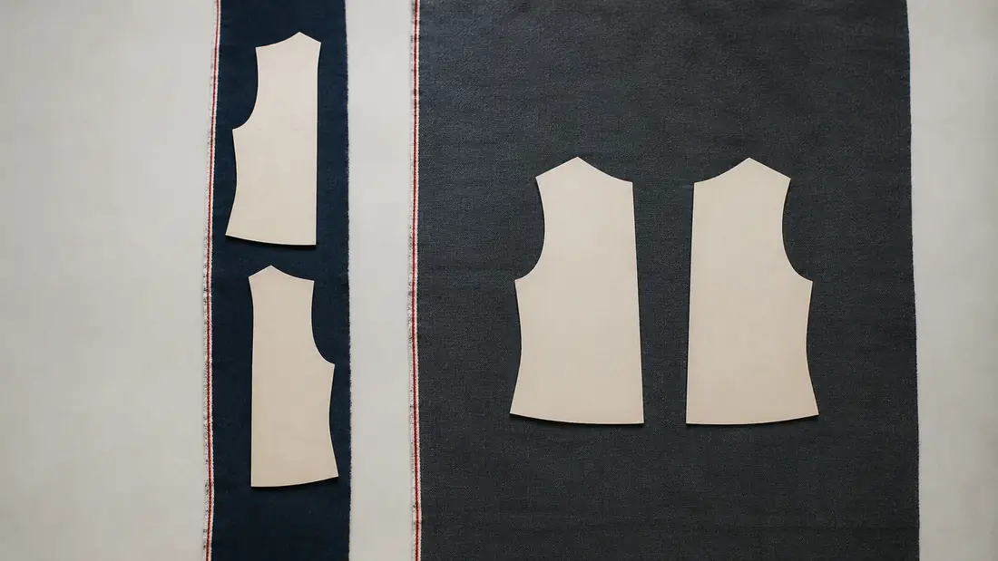 The same two paper pattern pieces laid on a narrow strip of cloth and on a wide one; the narrow strip forces them one below the other.